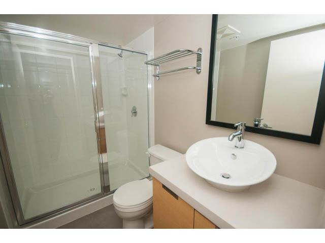 Bright bathroom with a modern sink, mirror, and shower. - 701 - 151 West 2nd Street, North Vancouver
