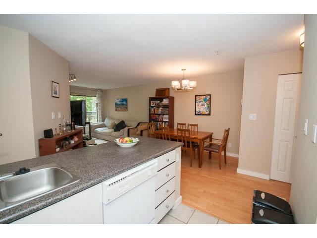 Bright kitchen with granite countertops, hardwood floors, and a city view. - 201 - 150 West 22nd Street, North Vancouver