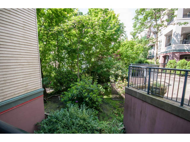 Bright balcony with lush greenery and city views. - 201 - 150 West 22nd Street, North Vancouver