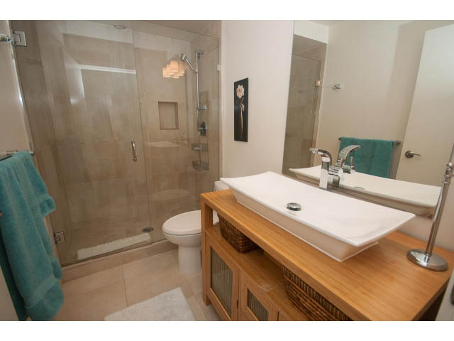 Furnished bathroom with wooden vanity, white sink, and teal towels. - Suite - 2985 Dollarton Hwy, North Vancouver