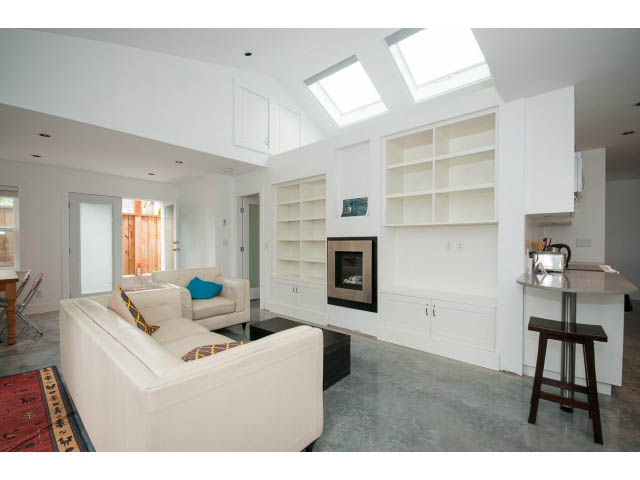 Bright kitchen with white cabinetry and open shelving, modern design, concrete floors. - 2 - 754 East 15th St, North Vancouver