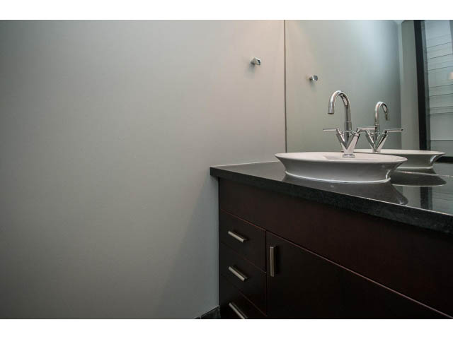 Modern bathroom with dark vanity and sleek sink design. - TH17 - 1233 West Cordova St, Vancouver Downtown