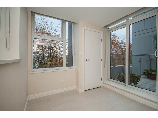 Bright living room with large windows, city view, and sliding glass doors leading to a patio. - TH17 - 1233 West Cordova St, Vancouver Downtown