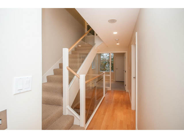 Furnished hallway leading to stairs with hardwood floors and glass railings. - TH17 - 1233 West Cordova St, Vancouver Downtown
