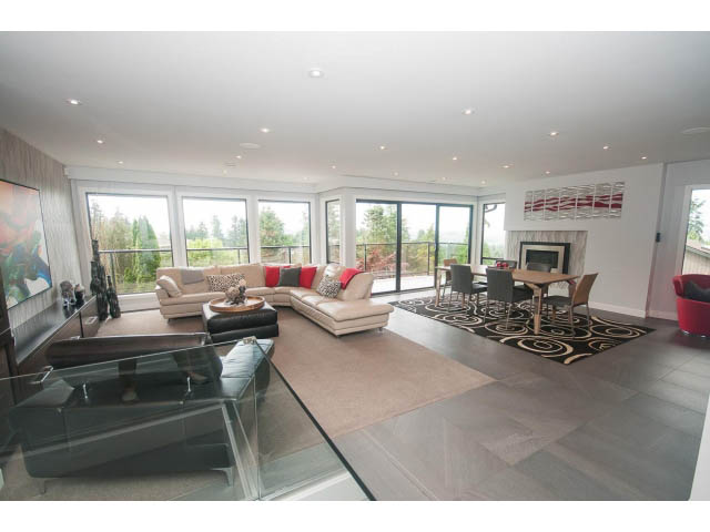 Spacious living room with modern furniture, large windows, and hardwood floors. - 2948 Marykirk Place, North Vancouver