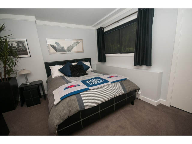 Furnished bedroom with black and white bedding, large window, and modern decor. - 2948 Marykirk Place, North Vancouver