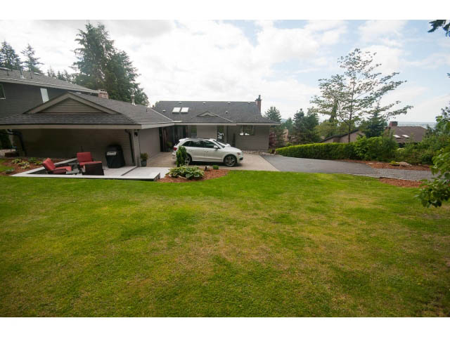 Spacious backyard with lush green lawn and patio area. - 2948 Marykirk Place, North Vancouver