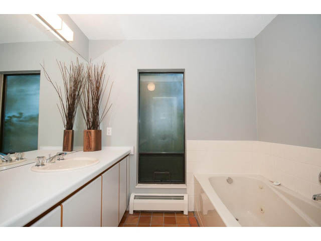 Spacious bathroom with white countertops, a large window, and a bathtub. - 5338 Montiverdi Pl, West Vancouver