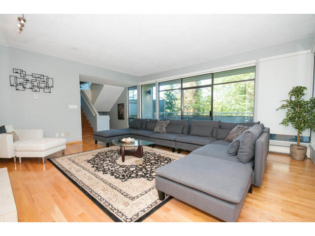 Spacious living room with hardwood floors, large windows, and a comfortable sectional sofa. - 5338 Montiverdi Pl, West Vancouver