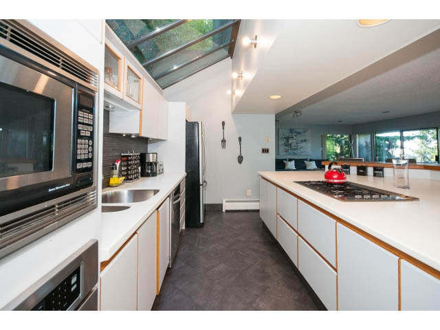 Bright kitchen with white cabinets, stainless steel appliances, and a skylight. - 5338 Montiverdi Pl, West Vancouver