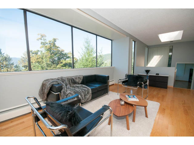 Bright living room with hardwood floors, large windows, and a city view. - 5338 Montiverdi Pl, West Vancouver