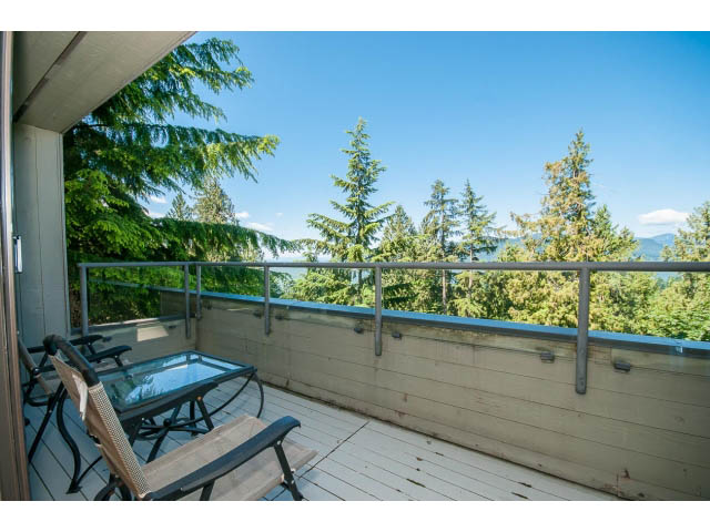 Furnished balcony with wooden deck, seating, and forest view. - 5338 Montiverdi Pl, West Vancouver