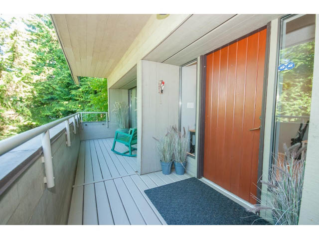 Furnished entryway with wooden doors, plants, and a small chair. - 5338 Montiverdi Pl, West Vancouver