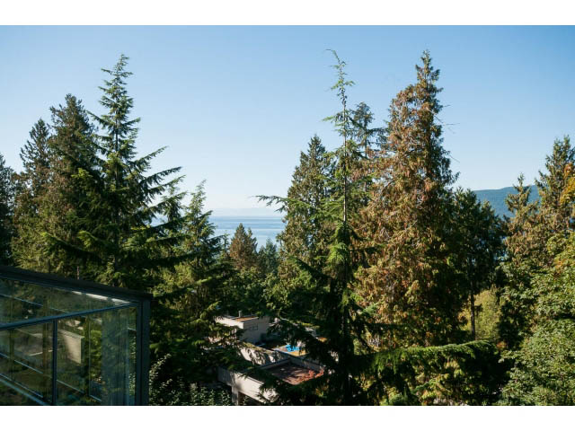 Bright living room with a stunning view of the ocean and lush greenery. - 5338 Montiverdi Pl, West Vancouver