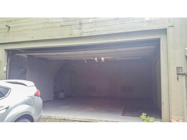 Garage with open door, concrete walls, and parked car inside. - 5338 Montiverdi Pl, West Vancouver