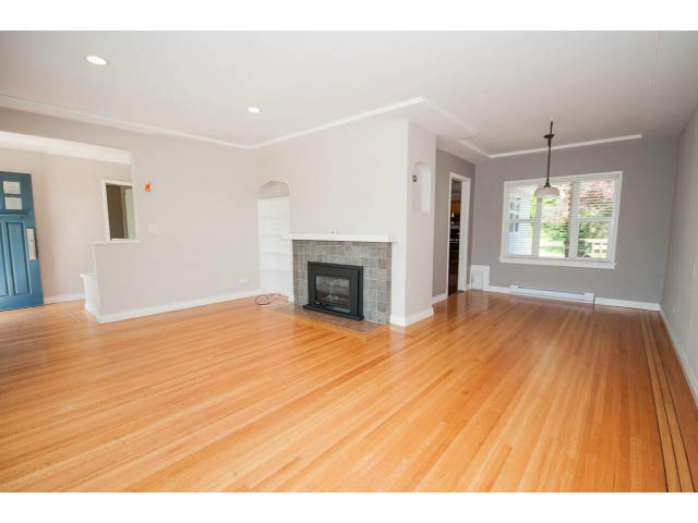 Spacious living room with hardwood floors and a fireplace. - 3626 Loraine Ave, North Vancouver