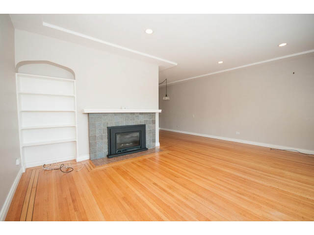 Bright living room with hardwood floors and a fireplace, showcasing a spacious and modern design. - 3626 Loraine Ave, North Vancouver