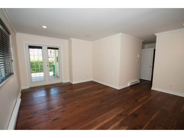 Bright living room with hardwood floors and French doors leading outside. - 3626 Loraine Ave, North Vancouver