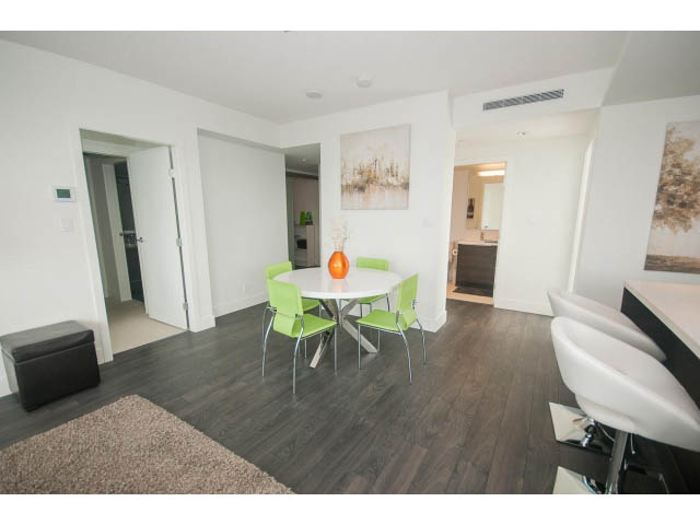 Furnished living room with hardwood floors, modern furniture, and a cozy rug. - 1504-1550 Fern Street, North Vancouver