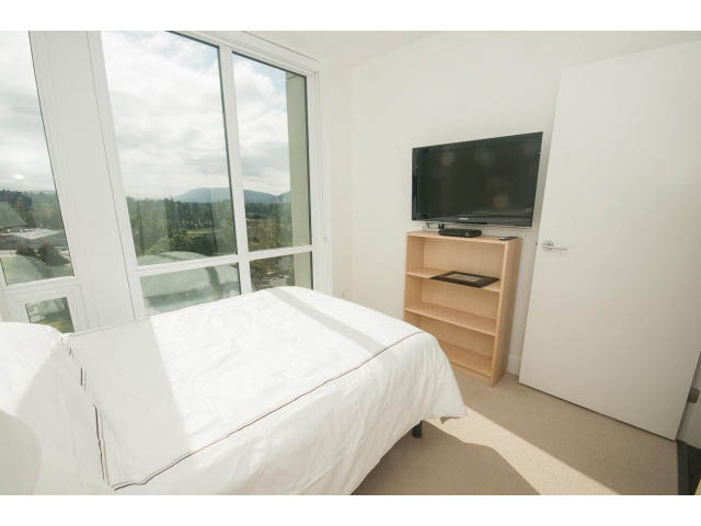 Bright bedroom with large windows, city view, and modern furniture. - 1504-1550 Fern Street, North Vancouver