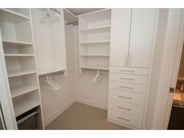 Furnished walk-in closet with built-in shelves and drawers, carpeted floor. - 1504-1550 Fern Street, North Vancouver
