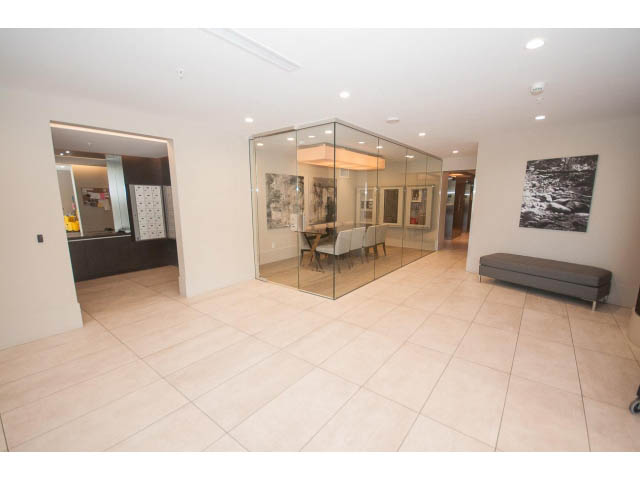 Furnished living room with glass walls, modern decor, and neutral tones. - 1504-1550 Fern Street, North Vancouver