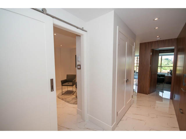Bright kitchen with marble countertops and sliding barn door entry. - 307 - 1490 Pennyfarthing Drive, Vancouver West Side