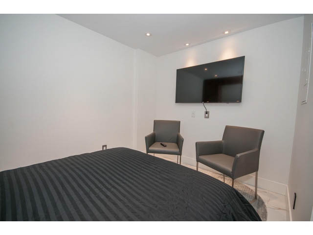 Furnished living room with a flat-screen TV and striped furniture. - 307 - 1490 Pennyfarthing Drive, Vancouver West Side