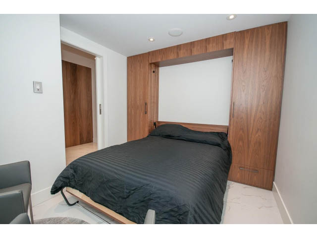 Furnished 2-bedroom condo with built-in Murphy bed, modern design, white walls, and wooden accents.