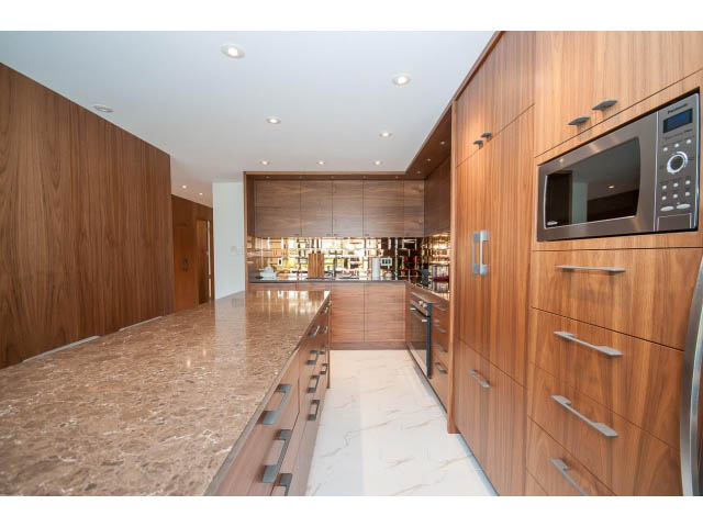 Bright kitchen with granite countertops and wooden cabinets, modern appliances. - 307 - 1490 Pennyfarthing Drive, Vancouver West Side