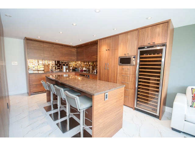 Bright kitchen with granite countertops, modern appliances, and a wine cooler. - 307 - 1490 Pennyfarthing Drive, Vancouver West Side