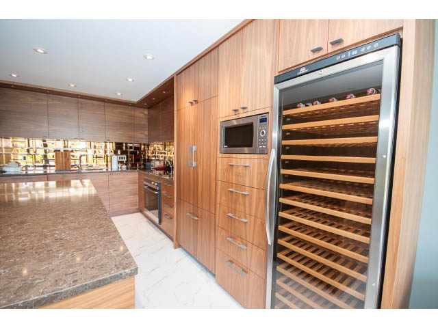 Bright kitchen with granite countertops, wood cabinetry, and a built-in wine cooler. - 307 - 1490 Pennyfarthing Drive, Vancouver West Side