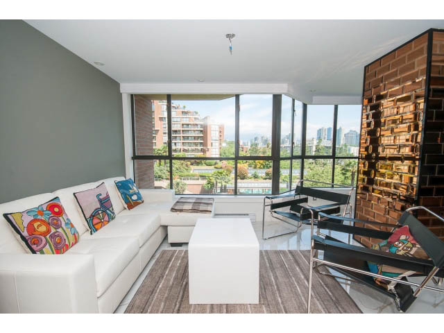 Bright living room with modern furniture, city view, and large windows. - 307 - 1490 Pennyfarthing Drive, Vancouver West Side