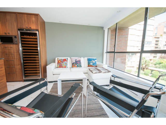 Furnished living room with city view and modern furniture. - 307 - 1490 Pennyfarthing Drive, Vancouver West Side