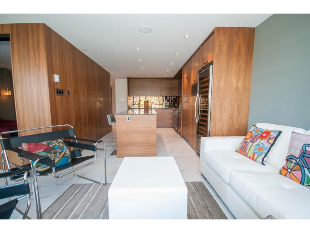 Furnished living room with white couch, colorful pillows, and modern decor. - 307 - 1490 Pennyfarthing Drive, Vancouver West Side