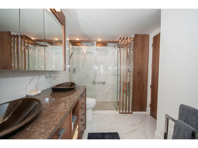 Furnished bathroom with marble countertops and wooden accents. - 307 - 1490 Pennyfarthing Drive, Vancouver West Side