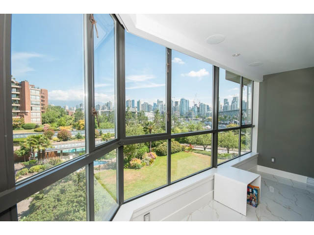 Bright living room with large windows, city view, and modern furnishings. - 307 - 1490 Pennyfarthing Drive, Vancouver West Side