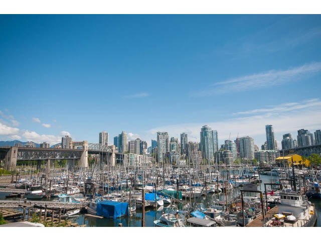 Bright living room with stunning city view and waterfront access. - 307 - 1490 Pennyfarthing Drive, Vancouver West Side