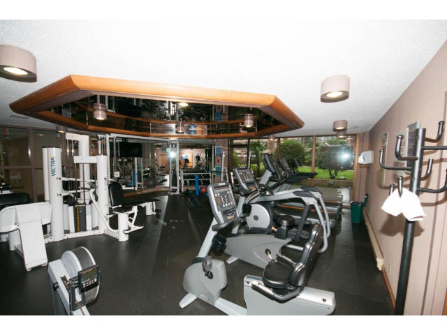 Bright gym with exercise bikes and mirrors, modern equipment setup. - 307 - 1490 Pennyfarthing Drive, Vancouver West Side