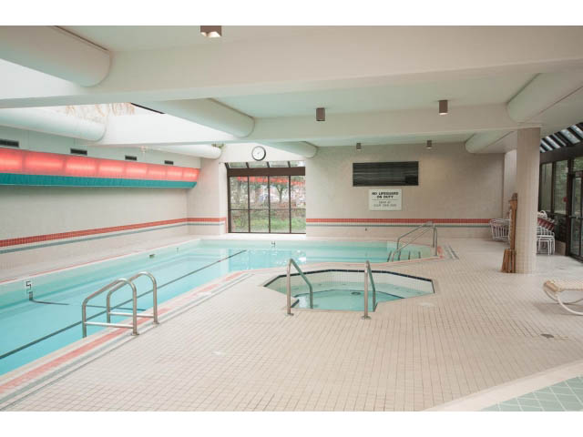 Spacious indoor pool area with tiled floors and railings. - 307 - 1490 Pennyfarthing Drive, Vancouver West Side