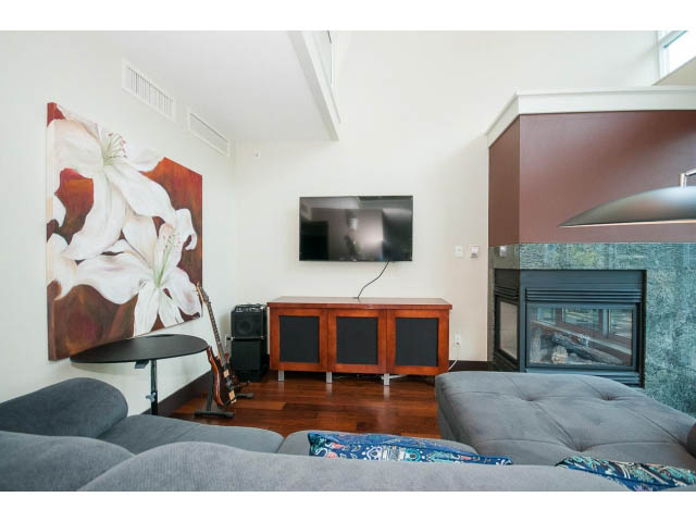 Bright living room with hardwood floors, modern decor, and a large floral painting. - 803 - 590 Nicola Street, Vancouver Downtown