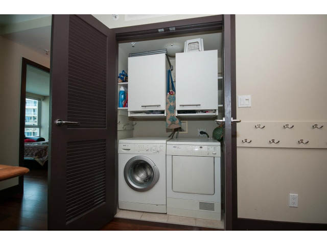 Bright laundry room with stacked washer and dryer, city view through open door. - 803 - 590 Nicola Street, Vancouver Downtown