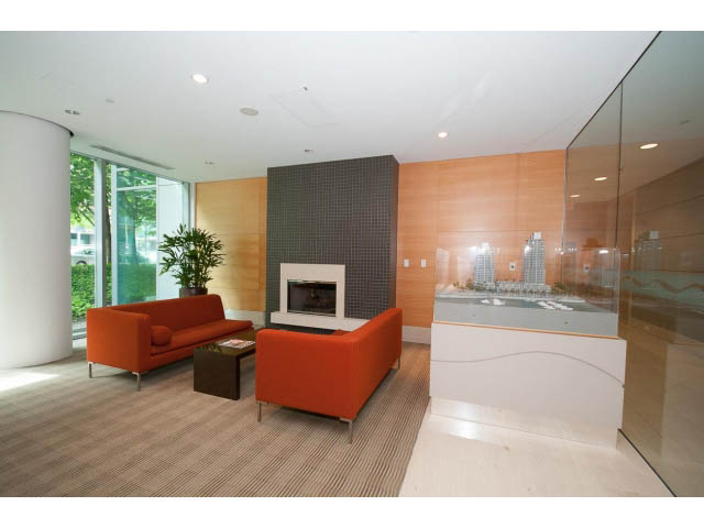 Bright living room with modern orange furniture, glass walls, and city view. - 803 - 590 Nicola Street, Vancouver Downtown