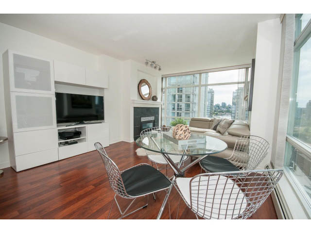Furnished living room with hardwood floors, city view, and modern furniture. - 1506 - 1199 Marinaside Cres, Vancouver Downtown