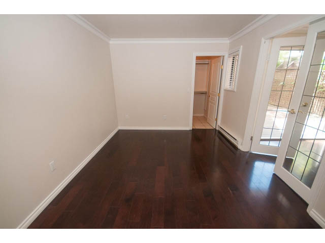 Bright living room with hardwood floors and a sliding glass door leading to the patio. - 1122 Ironwork Passage, Vancouver West Side
