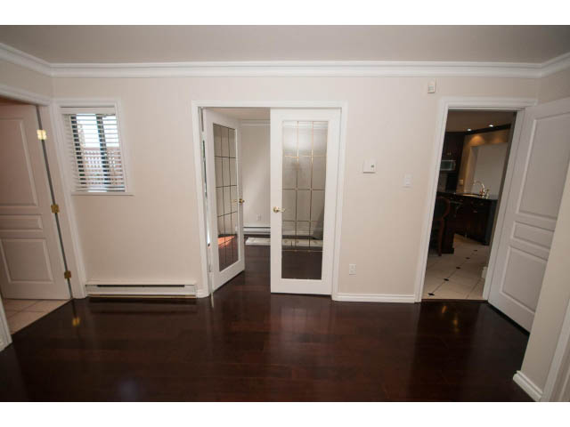 Bright open-concept living area with hardwood floors and modern cabinetry. - 1122 Ironwork Passage, Vancouver West Side