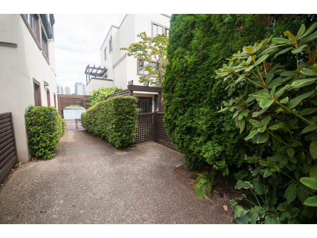 Furnished patio with lush greenery and paved walkway. - 1122 Ironwork Passage, Vancouver West Side