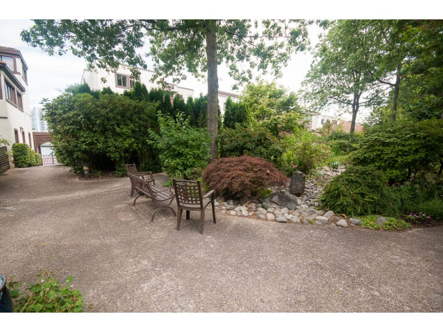 Furnished patio with stone seating and lush greenery. - 1122 Ironwork Passage, Vancouver West Side