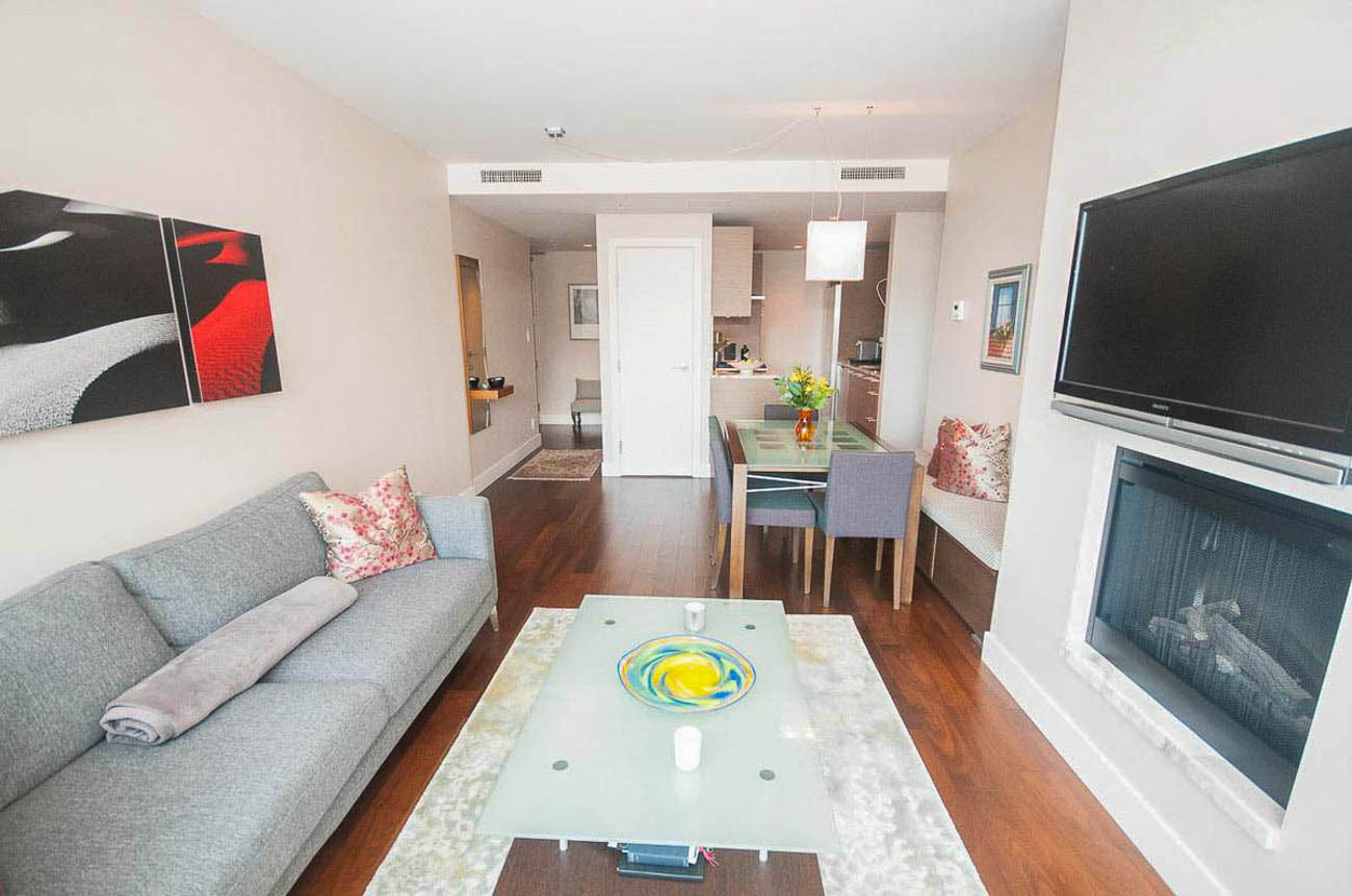 Furnished living room with hardwood floors, modern furniture, and a large flat-screen TV. - 2806 - 1111 Alberni Street, Vancouver Downtown
