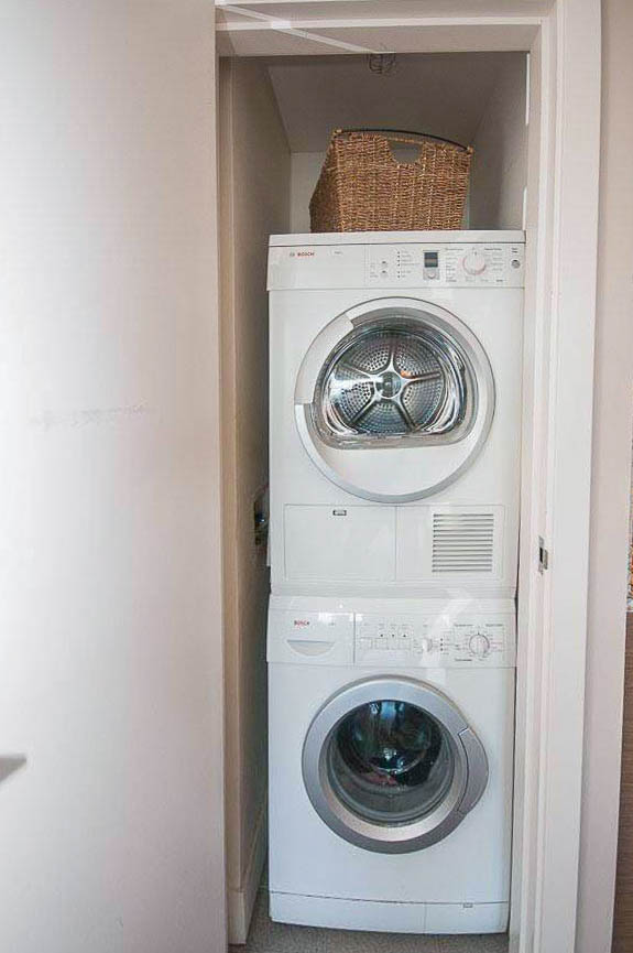 Bright laundry room with stacked washer and dryer, small basket on top. - 2806 - 1111 Alberni Street, Vancouver Downtown